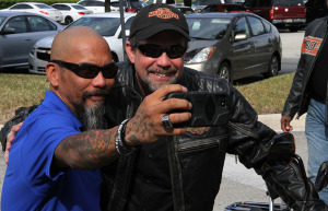 U.S. Marine veteran Raymond Andalio poses with Bill Davidson, great-grandson of Harley-Davidson co-founder William A. Davidson, after learning he would receive a 2015 Harley-Davidson motorcycle. 